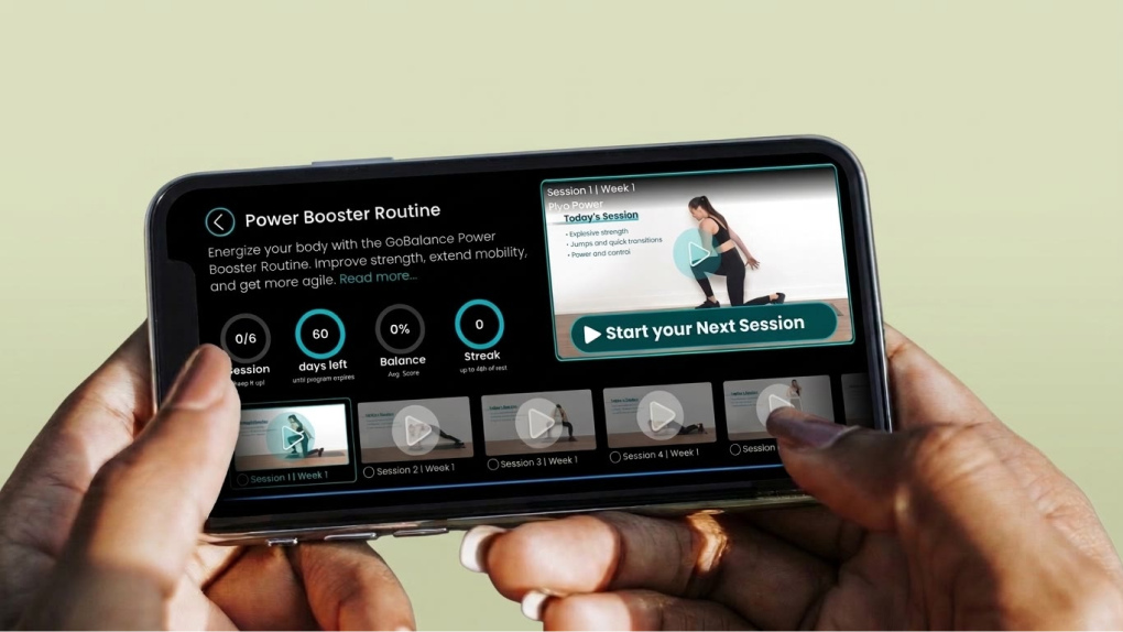 Hands holding a phone showing the GoBalance Power Booster Routine with weekly video sessions